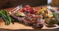 View of a sirloin steak with asparagus, potatoes and roasted tomatoes