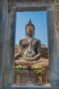 View of Sitting Buddha statue through stone door in the Ancient temple Thailand Royalty Free Stock Photo