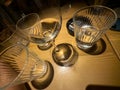 view of skewed bar glassware casting distorted reflections on a wooden table, evoking a drunk perspective and the effects of Royalty Free Stock Photo