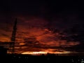 A view of the sky at dawn or dusk, characterized by dramatic contrast and the silhouette of an electric tower. Royalty Free Stock Photo