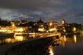 Skyline at night of Murten in Switzerland with the harbor and pier and boat in the foreground Royalty Free Stock Photo