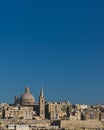 Skyline of Valletta, Malta under blue sky, with dome of Basilica of Our Lady of Mount Carmel and tower of St Paul`s Pro-Cathedral