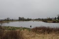 A view of a slow river with a grassy bank