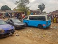 View of slum with a exterior market in the Luanda city downtown center with clay road, people, vehicles and buildings