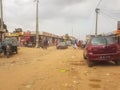 View of slum in the Luanda city downtown center with clay road, people, vehicles and buildings