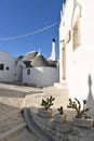 View of a small alley with trulli houses in Alberobello, Apulia - Italy