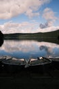 View Of Small Boats On A Shore Of A Lake With Reflection Of The Sky In The Water Surface