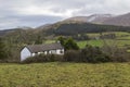 A view of a small cottage at the foot of the snow capped peaks of the mountains of Mourne in County Down Northern Ireland Royalty Free Stock Photo