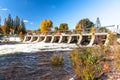 Dam on a river under blue sky in autumn Royalty Free Stock Photo