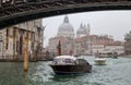 View of a small ferries on Canal Grande in a foggy day with historic Basilica di Santa Maria della Salute in the background in Ven