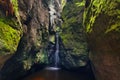 View of the small flow of water between the rocks. Waterfall in the mountains.