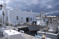 View of a small harbor with fishing boats and a taverna by a church at Naoussa, Paros, Greece.