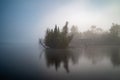 View of a small island on a foggy lake Royalty Free Stock Photo