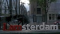 View of small plastic figure of Iamsterdam letters sculpture on the bridge against blurred cityscape, Amsterdam