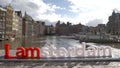 View of small plastic figure of Iamsterdam letters sculpture on the bridge against blurred cityscape, Amsterdam