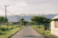 view of the small road in the village, rice fields, and beautiful mountains with clouds