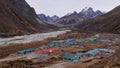 View of small Sherpa village Pheriche located in a valley with riverbed and snow-covered mountain range in Nepal.