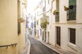 View of small street with white houses and flowers in the traditional spanish town of Sitges in the Catalonia region Royalty Free Stock Photo