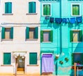 Narrow street with blue and yellow house facade in the island of Burano, Venice