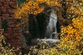 View of a small village waterfall through the autumn foliage Royalty Free Stock Photo