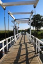 View on small white wooden drawbridge in rural landscape against blue summer sky - Kinderdijk, Netherlands Royalty Free Stock Photo