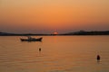 View of small, wooden fishing boat, Aegean sea and landscape at sunset captured in Ayvalik area of Turkey in summer.