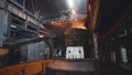 View of smelting of metal with ladle inside foundry. Footage. Interior of dirty metallurgical plant in dark. Concept of