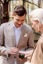 View of smiling man putting on wedding ring on woman finger in forest Royalty Free Stock Photo