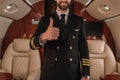 View of smiling pilot of private jet showing thumb up Royalty Free Stock Photo