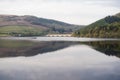 View of the smooth lake and a bridge with green hills. Lady Bower Reservoir, Peak District, UK. Royalty Free Stock Photo