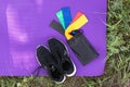 View from Sneakers, elastic rubber band on exercise mat background outdoor, top view. Royalty Free Stock Photo