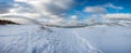 View of snow-covered beach during sunny winter day with blue sky and clouds. Baltic sea coast. Dunes covered in snow Royalty Free Stock Photo