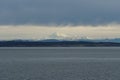 View on snow covered mountain form merchant vessel approaching Vancouver, British Columbia from Pacific ocean under heavy rainfal