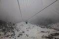 View of snow-covered mountain slope in dense fog with Tsongo passenger ropeway in Gangtok, Sikkim Royalty Free Stock Photo