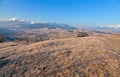 View of snowcovered mountains from a pture in early spring.