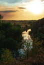 The view on the solitude river,trees and field in some rural area in the sunset.