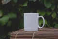 A solo blank white coffee mug on the bamboo table edge Royalty Free Stock Photo