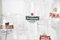 Close up of beer glasses, with the logo of some main beer brands. Heineken, Pimm, Tuborg.