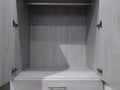 view of a spacious, empty gray cabinet inside a large walk in closet Royalty Free Stock Photo
