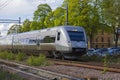 View of speed electric train passing crossroad in town. Uppsala. Sweden.