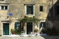 View of a square in the historical center of the city of Corfu in Greece some white plastic chairs under a pergola in front of an