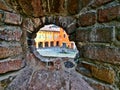 View of a square through a hole on the walls of Rocca Sanvitale, Castello Di Fontanellato, Emilia Romagna. Italy