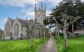 View of St Michael the Archangel church with pollarded church yard path in Mere, Wiltshire, UK Royalty Free Stock Photo