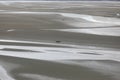 View from St. Michel mountain in France during low tide and groups of tourists in the middle of the beach