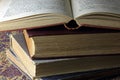 A STACK OF OLD BOOKS WITH AN OPEN BOOK ON TOP Royalty Free Stock Photo