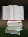 View of stacked books with an open book with blank pages on it Royalty Free Stock Photo