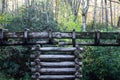 View of a stacked log support for a water sluice, autumn leaves and rhododendrons