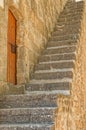 view of stairs in front of an old wooden door in a stone wall in Denia, Spain Royalty Free Stock Photo