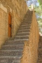 view of stairs in front of an old wooden door in a stone wall in Denia, Spain Royalty Free Stock Photo