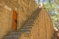 View of stairs in front of an old wooden door in a stone wall in Denia, Spain Royalty Free Stock Photo